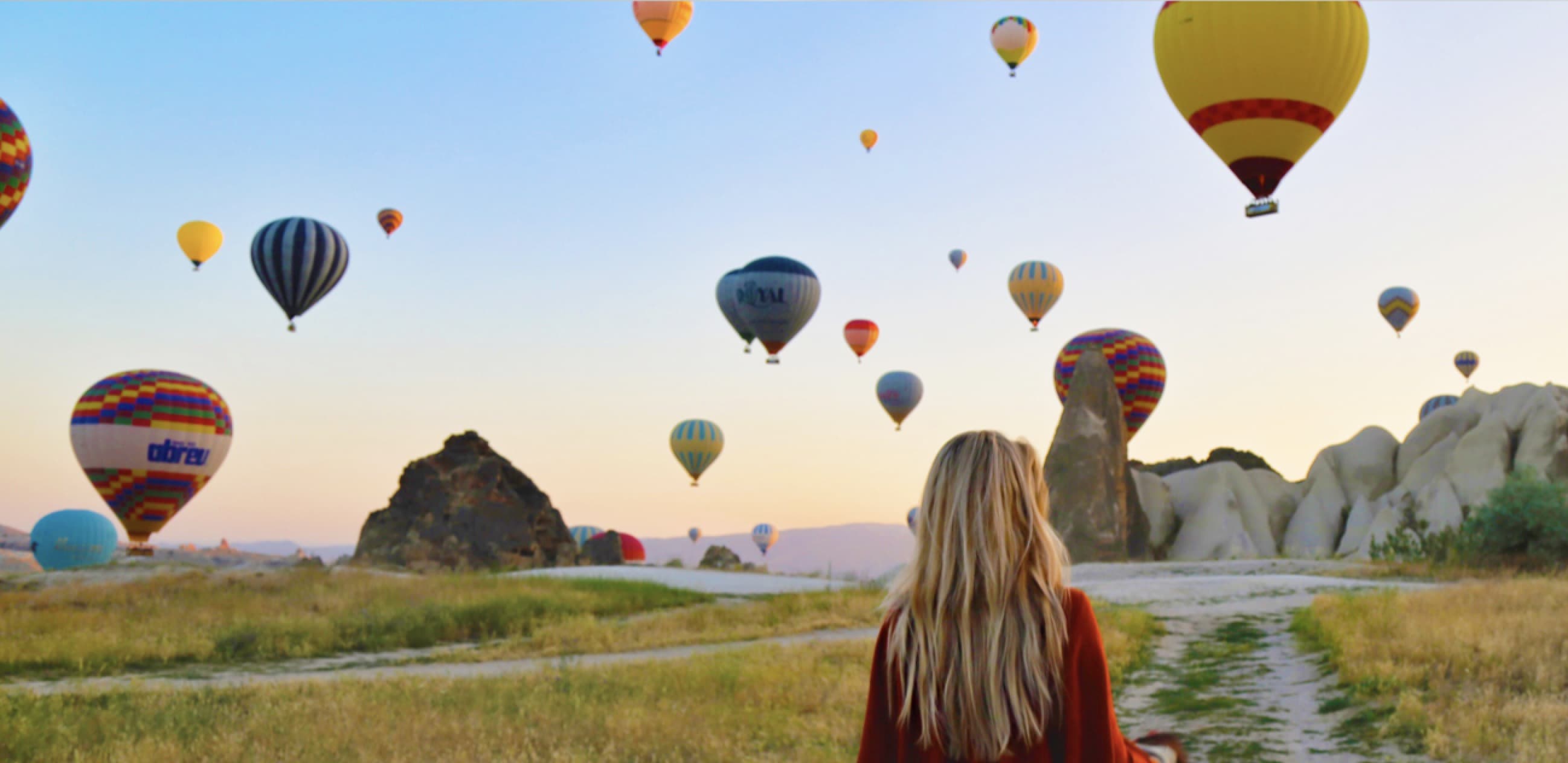 Person with arms raised high with notebook in one hand and card in other hand