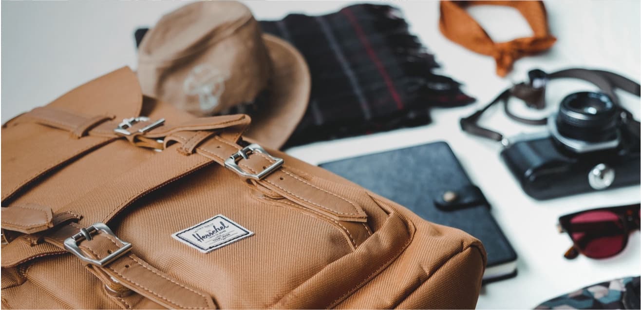 Tan backpack in foreground with accessories in background