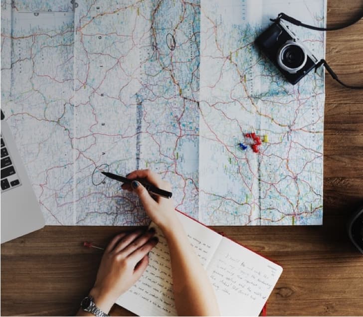 Woman overlooking mountain landscape with hot air balloons in foreground